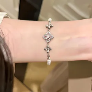Detailed close-up of a french vintage floral rhinestone pearl bracelet worn on wrist, elegant.