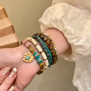 Forest style multi-layer beaded bracelet set with heart charm, elegant resort style wrist jewelry.
