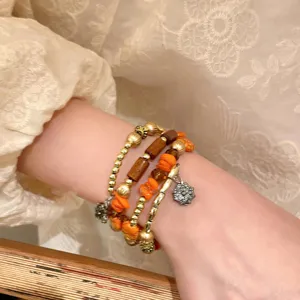 Close-up detail of multi-layer beaded bracelet set, featuring unique textures and charms.