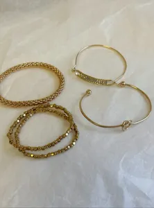 Σετ χρυσά βραχιόλια λεπτομέρεια με boho χάντρες δίχτυ και κομψά βραχιόλια κόμπος.