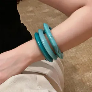 Detailopname van turquoise hars armbanden met subtiele kleurverloop en gladde textuur.