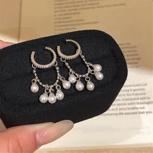 Silver C-shaped hoop clip earrings with delicate pearl tassel chains and elegant design.