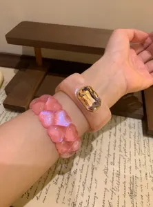 Pink resin bangle and heart glitter bracelet set, sweet style women fashion wrist jewelry detail.