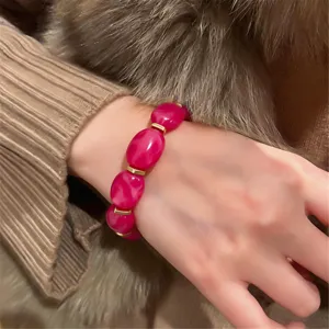 Close-up detail of the rose red acrylic bead elastic bracelet, showing texture and style.
