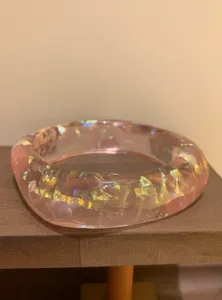 Detail shot of a stylish pink resin bracelet filled with colorful glittering sequins, elegant.