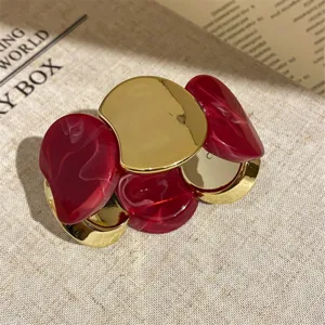 Close-up detail of rosy ombre acrylic and gold metal link bracelet, chic fashion jewelry.