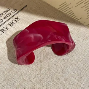 Close-up detail of the pink marble acrylic wide cuff bracelet showcasing the smooth glossy finish.