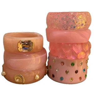 Set of pink resin bracelets featuring sparkling rhinestones, pearls, and cute hearts.