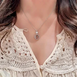 Gros plan détaillé d'un collier en argent très délicat avec pendentif étoile et verre rond.