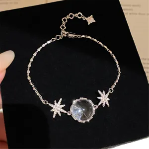 Gros plan sur le bracelet étoile argenté avec zircone cubique et pendentif globe.