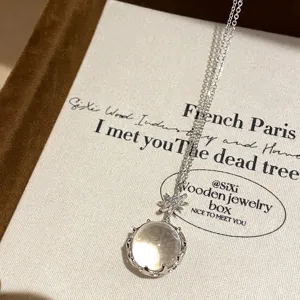 Collier en argent avec connecteur étoile scintillant et pendentif cristal transparent rond.