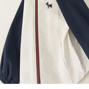 Detailed shot of kids color-blocked jacket with raglan sleeves and cute embroidery.