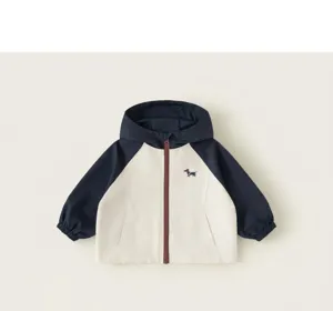 Close-up detail view of children's contrast color hooded jacket with raglan sleeves and zipper.