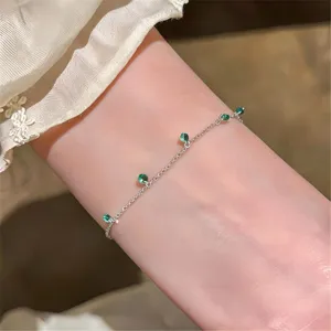 Nahaufnahme des zarten Silberkettenarmbands mit mintgrünen Perlen im minimalistischen Sommerstil.