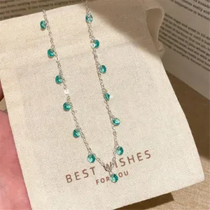 Zarte silberne Halskette mit klaren mintgrünen runden Steinen, frischer Sommer-Schmuck-Stil.