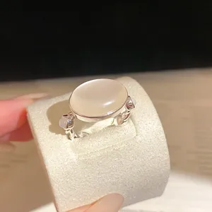 Gros plan détaillé de la bague florale ajourée style français avec pierre laiteuse.