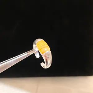 Gros plan détaillé de la bague en argent réglable avec une pierre centrale en ambre jaune.