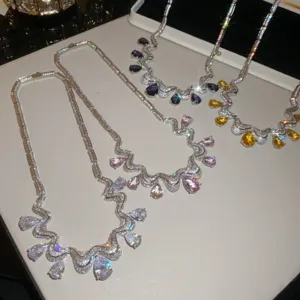 Detailed view of sparkling cubic zirconia teardrop pendant necklaces on a white display tray.