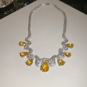 Detailed shot of sparkling yellow teardrop zircon pendant necklace, luxury silver chain