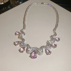 Detail view of luxury pink pear zircon necklace with sparkling wavy paved cubic zirconia.
