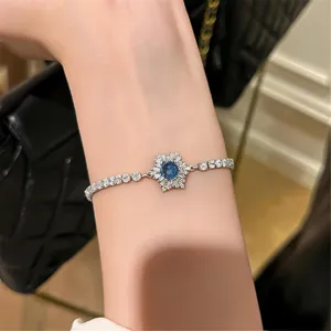 Nahaufnahme Detailansicht eines glitzernden blauen Kristall Stern Armbands am feinen Handgelenk.