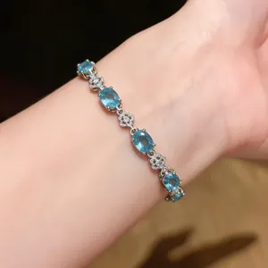 Elegant silver-tone bracelet featuring blue oval stones and delicate floral motifs for women.