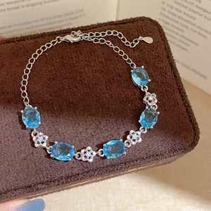 Elegant silver-plated bracelet featuring blue oval stones and sparkling crystal flower charms.