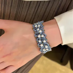 Primer plano detallado de una pulsera de cuentas tejidas a mano con cuentas de perlas azules.
