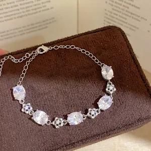 Detailed close-up view of silver-tone oval zirconia floral cluster charm bracelet.