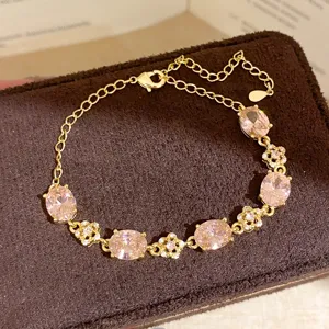 Close-up of elegant gold-plated bracelet with sparkling pink oval cubic zirconia stones.