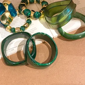 Green resin bangle set and beaded bracelet detail view, vintage dark green marble pattern style.