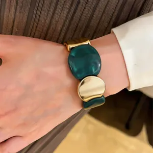Dark green resin and gold metal chunky statement bracelet detail shot fashion accessory.