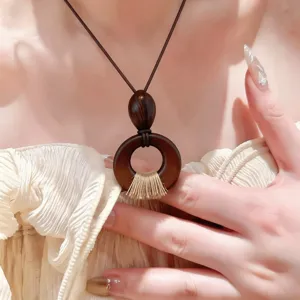 Collier pendentif en bois avec cordon en cuir, style minimaliste chic pour femme.