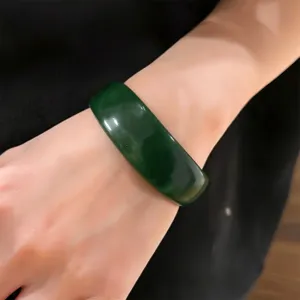 Close-up view of the dark green resin round bracelet showcasing fine texture and glossy finish.