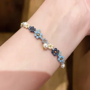 Zartes Perlenarmband mit blauen und weißen Perlen sowie goldenen Akzenten für jeden Tag.