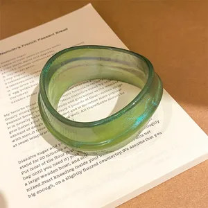 Green resin bangle bracelet with subtle textured finish, detail shot of trendy aesthetic jewelry