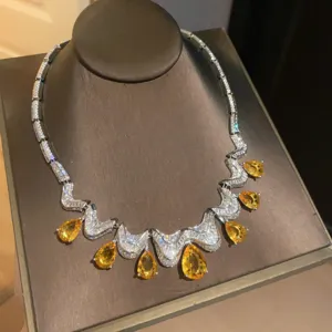 Close-up detail of silver zircon teardrop pendant necklace with sparkling yellow crystal drops.