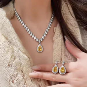 Nahaufnahme eines eleganten gelben Zirkonia Halskette und Ohrringe Sets im Tropfendesign.
