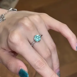 Close-up van een blauwe zirkonia open ring om een vinger met schitterende steentjes.