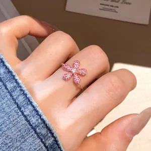 Gedetailleerde close-up van een roze bloemvormige zirkoniaring met chique roségouden afwerking.