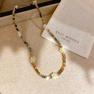 Detailed shot of colorful crystal beaded floral necklace with delicate daisy charms and shiny beads.