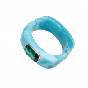 Brazalete rígido cuadrado de resina jaspeada azul con elegante cristal de estrás verde.