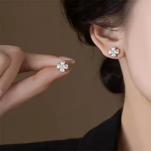 Exquisite four-petal clover zirconia stud earrings detail shot, elegant shining design.