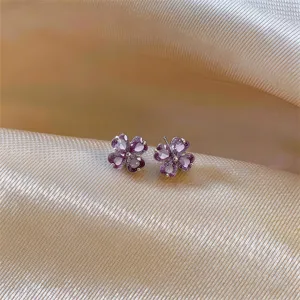 Purple four-leaf clover crystal heart stud earrings detail view, delicate metal jewelry.
