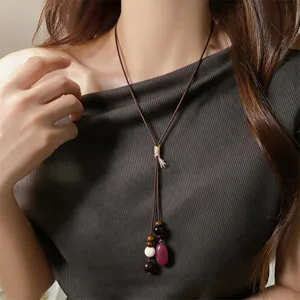 Ethnic vintage long necklace with brown leather cord, wood beads and gemstone pendant.