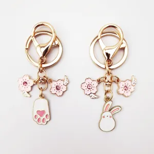 Cute alloy keychain detail showing cute pink bunny and sakura charms for stylish bags.