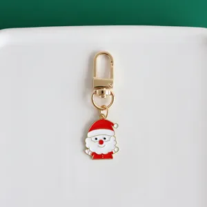 Charming metal Santa Claus keychain pendant detail view, golden hardware, vibrant colors.