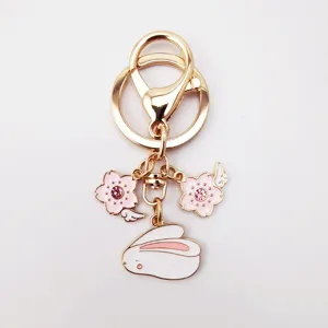 Cute alloy keychain featuring pink sakura cherry blossom and cute rabbit charms, detail view.