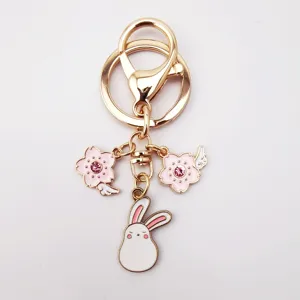 Cute alloy keychain featuring pink sakura crystal charms and a sweet white rabbit pendant.