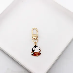 Close-up detail of the cute devil cartoon enamel keychain charm with gold clasp and ring.